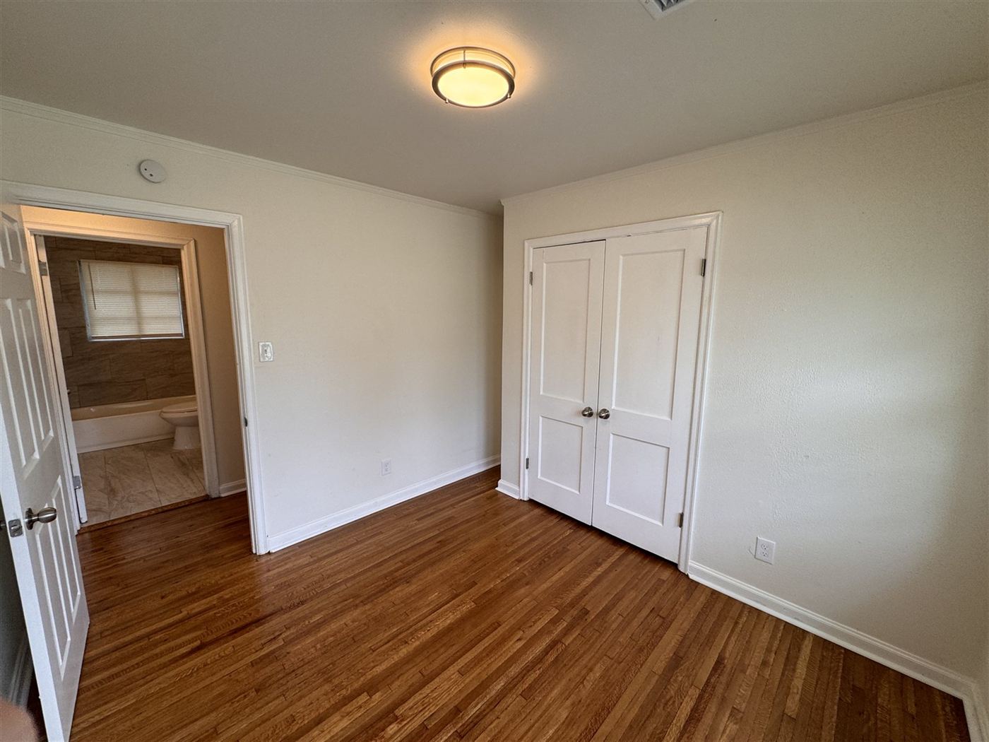 Refreshed bedroom with refinished flooring and new paint by Delta Construction in Memphis, TN